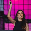 A influenciadora e empresária Bianca Andrade durante palestra de 20 minutos na Web Summit Rio; ela está sorridente e segurando microfone