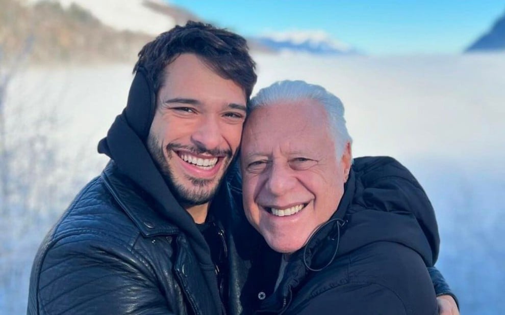 Bruno e Antonio Fagundes estão abraçados e usam roupas de frio; ao fundo é possível ver neve