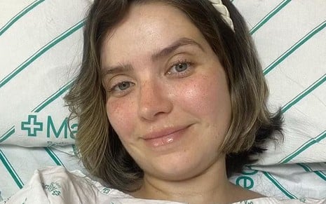 Camila Campos deitada em um leito de hospital
