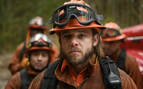 Max Thieriot usa trajes de bombeiro em cena da série Fire Country