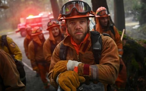 Com traje de bombeiro, Max Thieriot posa diante de outros profissionais em foto da série Fire Country