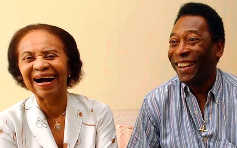 Celeste Arantes está sorrindo ao lado de Edson Arantes do Nascimento, o Pelé