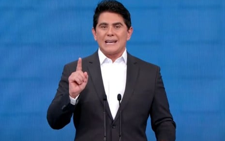 Cesar Filho usa terno preto e levanta dedo durante apresentação de debate