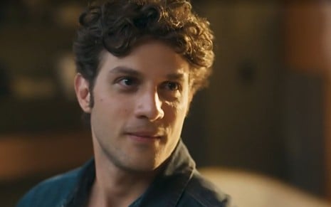 Em cena do trailer de Mania de Você, Chay Suede aparece olhando para alguém com um sorriso de canto de boca