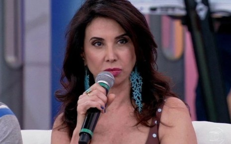 A atriz Claudia Alencar segurando microfone no Encontro
