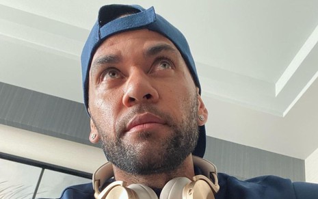 Daniel Alves em foto do Instagram, com boné para trás e fone de ouvido no pescoço