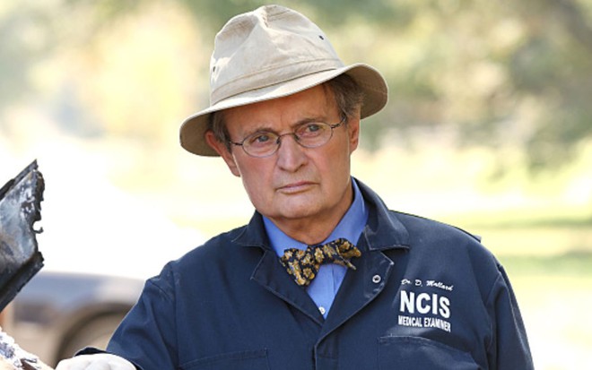 David McCallum usa camisa com o logo da NCIS e um chapéu em cena da série