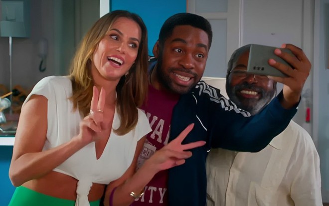 Lara (Deborah Secco), Mário (Lázaro Ramos), Evilásio (Cosme dos Santos) tiram selfie em cena da novela Elas por Elas