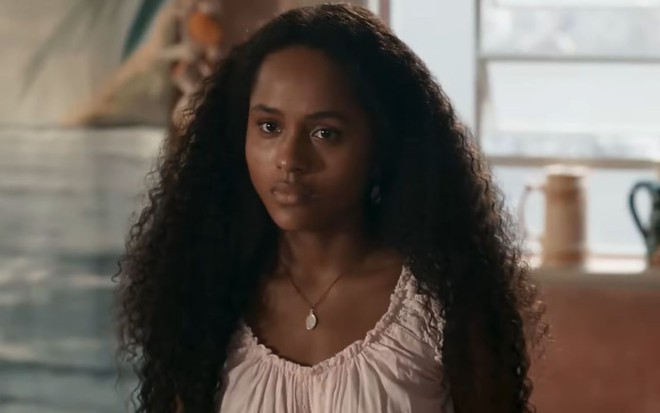 Duda Santos com es cabelos soltos e expressão séria em cena da novela Renascer