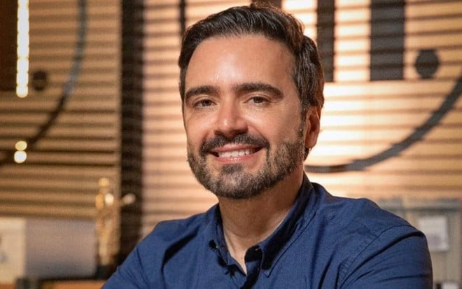 O autor de Família É Tudo, Daniel Ortiz, posa para foto sorrindo em cenário da novela