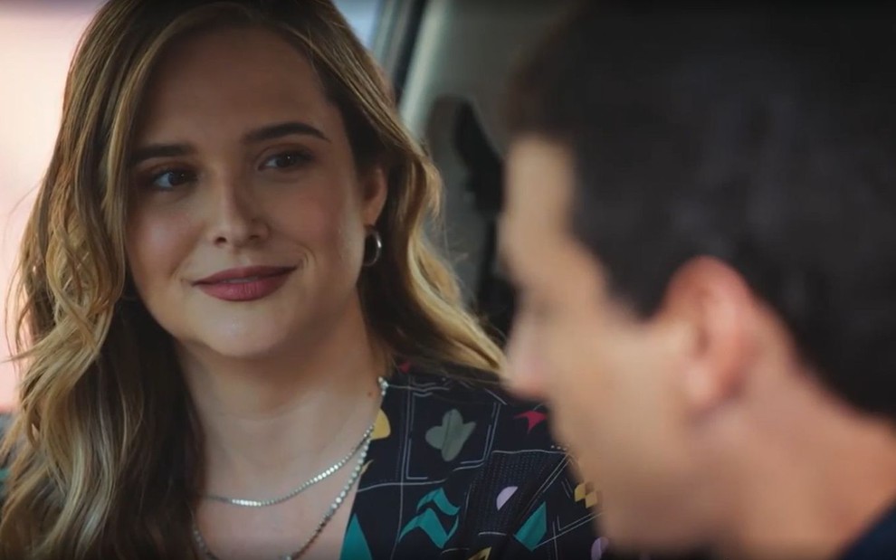 Em cena de Família É Tudo, Juliana Paiva olha com carinho para Henrique Barreira; eles estão dentro de um carro