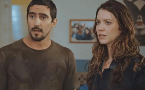 Os atores Renato Góes e Nathalia Dill um ao lado do outro, sérios, em cena de Família È Tudo