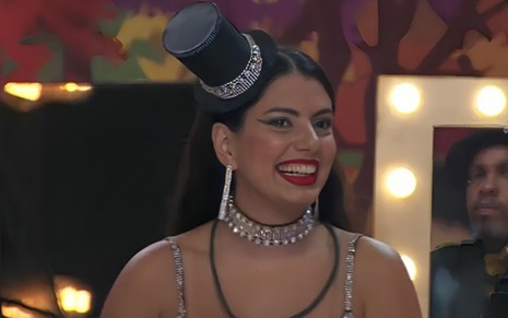 Fernanda Bande sorrindo no BBB 24, com cartola na cabela e colar de brilhantes
