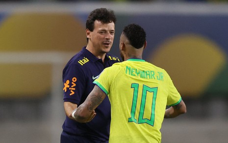 O técnico Fernando Diniz e Neymar (de costas) se cumprimentam em jogo da Seleção Brasileira