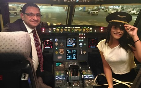 Geraldo Medeiros e sua filha, Vitória Medeiros, estão na cabina de piloto de um avião