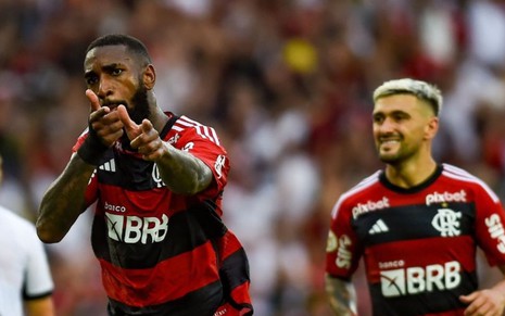 Gerson e Arrascaeta comemoram gol do Flamengo em jogo do Campeonato Brasileiro; eles usam uniforme tradicional rubro-negro