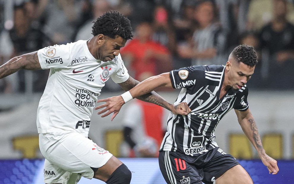 Gil puxa a camisa de Paulinho enquanto tenta recuperar a bola em jogo entre Corinthians e Atlético-MG