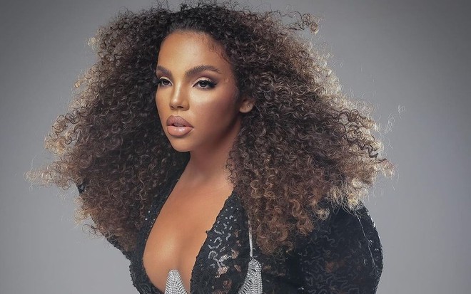 Giovanna Pitel está com vestido preto, decotado, cabelos soltos e posa para a foto fazendo carão