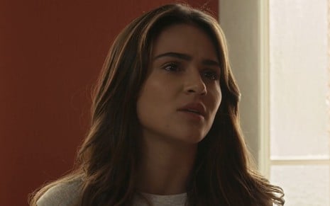 Giullia Buscacio com expressão séria em cena da novela Renascer