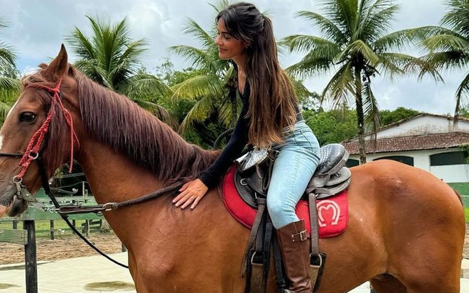 Giullia Buscacio está montada em cavalo durante aula de equitação