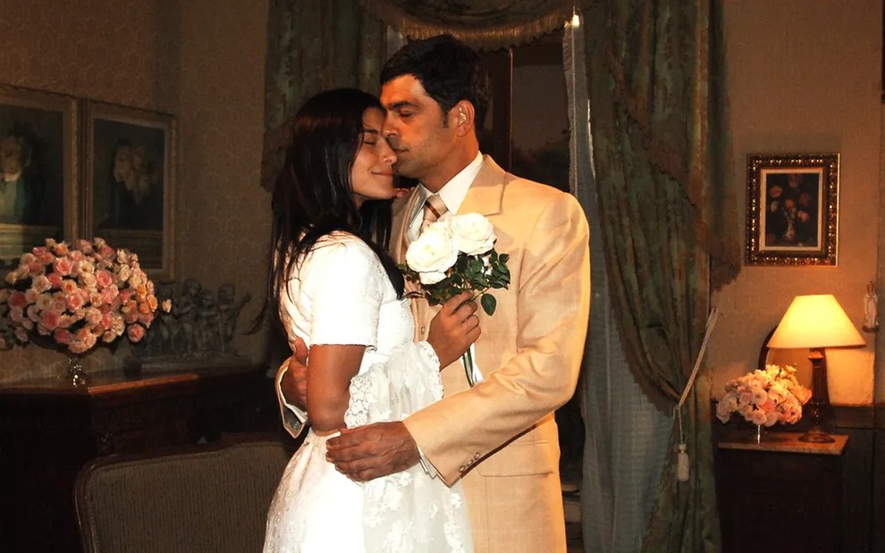 Priscila Fantin e Eduardo Moscovis estão vestidos como noivos em cena de Alma Gêmea