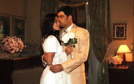 Priscila Fantin e Eduardo Moscovis estão vestidos como noivos em cena de Alma Gêmea