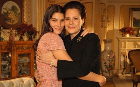 Priscila Fantin e Elizabeth Savala se abraçam em sala cenográfica da novela Alma Gêmea, da Globo