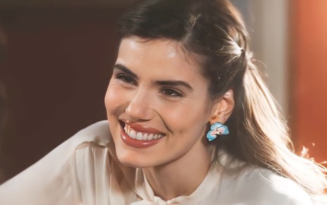 A atriz Camila Queiroz está sorrindo como Marê em cena da novela Amor Perfeito