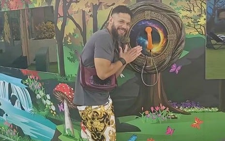 Juninho ao lado do Big Fone no jardim do Big Brother Brasil 24