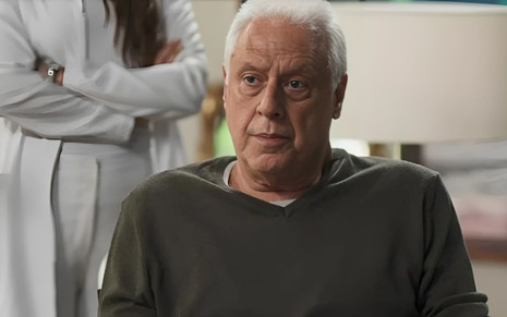 Antonio Fagundes caracterizado como Alberto em Bom Sucesso (2019); ele tem os cabelos brancos e está numa cadeira de rodas. O semblante exprime choque.