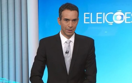 A imagem mostra um apresentador de TV vestindo terno preto e gravata cinza em um estúdio com fundo azul que exibe a palavra "ELEIÇÕES".