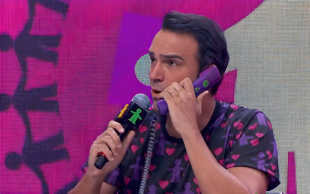 Tadeu Schmidt fala no telefone no Criança Esperança