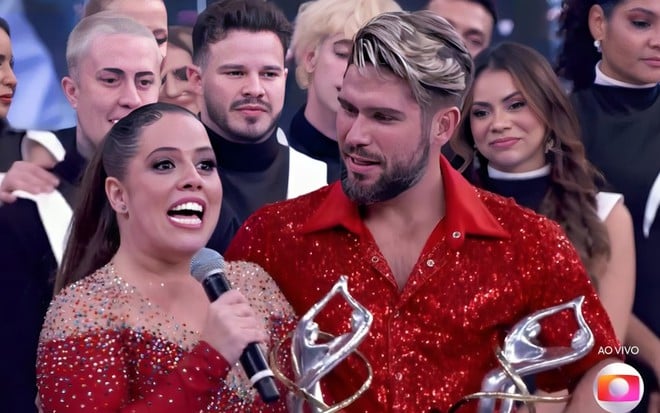 Tati Machado está em choque com troféu da Dança dos Famosos, enquanto Diego Maia sorri para ela