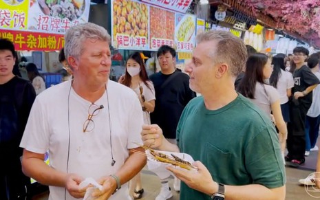 O cinegrafista José SIlveira Jr. está ao lado de Luciano Huck em uma feira típica chinesa