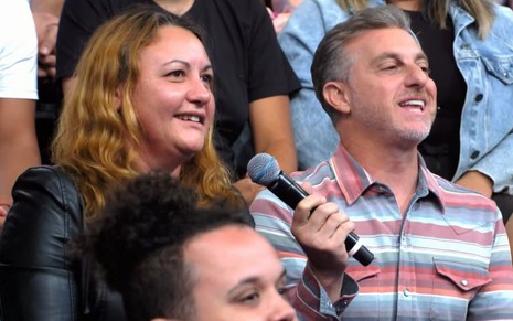 Nete Tavares e Luciano Huck estão sentados na plateia do Domingão de 8 de outubro de 2023