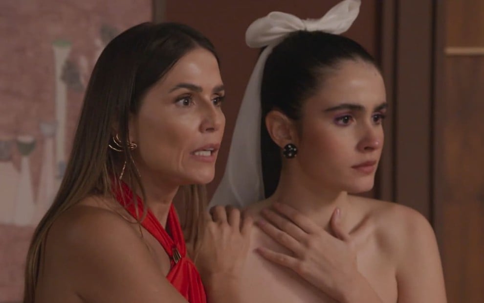 Deborah Secco, a Lara, segura Valentina Herszage, a Cris, pelos ombros; as duas aparentam estar chocadas em cena de Elas por Elas