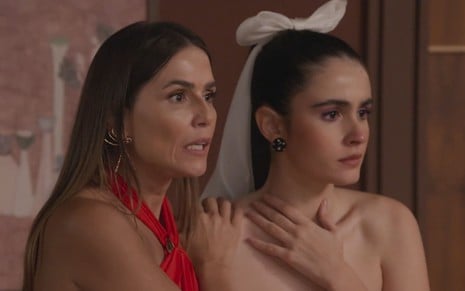 Deborah Secco, a Lara, segura Valentina Herszage, a Cris, pelos ombros; as duas aparentam estar chocadas em cena de Elas por Elas