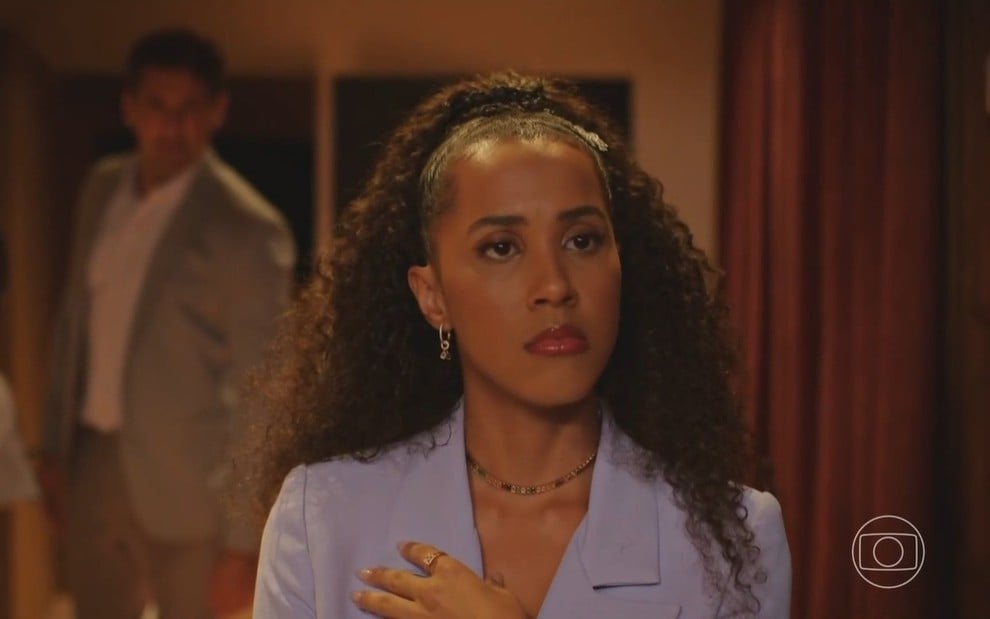 Ramille usa terno lilás e está com expressão séria em cena da novela Família É Tudo, da Globo, como Andrômeda