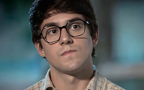 O ator Daniel Rangel usa óculos de grau e está em close em cena da novela Família É tudo, da Globo, como Guto