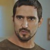 O ator Renato Góes com expressão séria em cena de Família É Tudo
