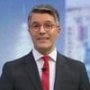 Bruno Tavares força um sorriso no cenário do Jornal da Globo