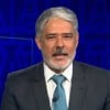 William Bonner está na bancada do Jornal Nacional, com expressão séria; ao fundo, a imagem de Rebeca Andrade com medalha de ouro