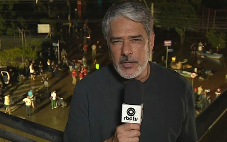 William Bonner de camisa preta apresentando o Jornal Nacional diretamente de Porto Alegre