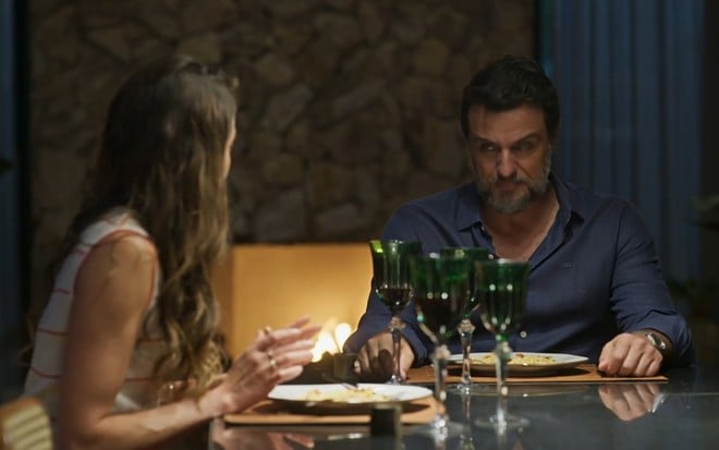 Agatha Moreira e Rodrigo Lombardi estão à mesa em cena de Mania de Você; ele tem expressão furiosa