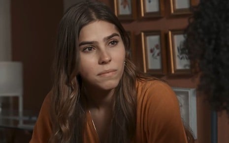 Gabriela Medeiros caracterizada como Buba; a personagem está séria em cena de Renascer