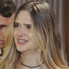 A atriz Juliana Paiva está chorando em cena de Família É Tudo, com Henrique Barreira atrás dela