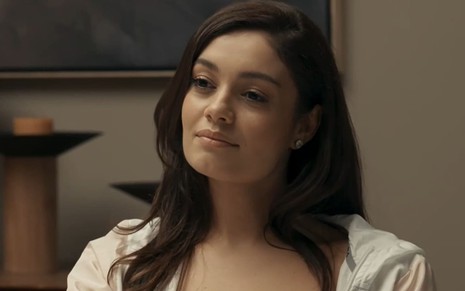 Sophie Charlotte caracterizada como Eliana; ela dá um sorriso irônico em cena de Renascer