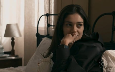 Sophie Charlotte está com a mão na boca e olha para o lado em cena da novela Renascer como Eliana
