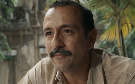 Irandhir Santos com expressão séria em cena como Tião Galinha na novela Renascer