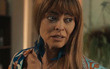 Juliana Paes caracterizada como a Jacutinga mais velha; sua pele está cheia de rugas, e ela usa uma peruca loira em cena de Renascer